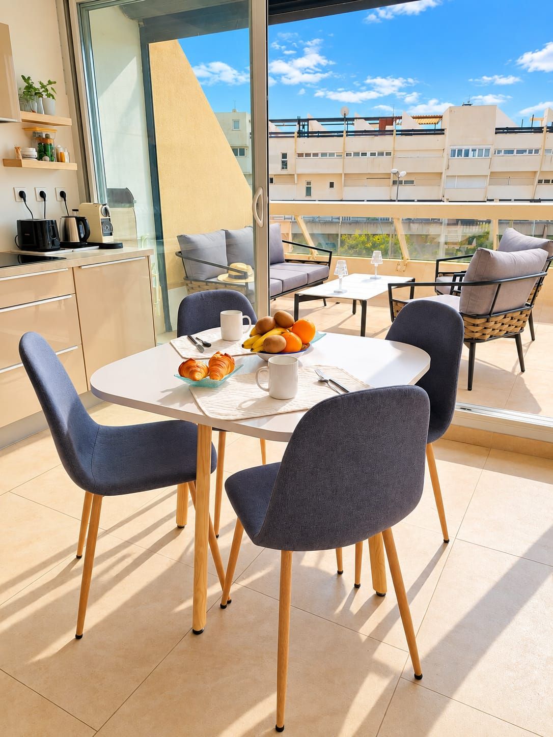 Table du petit-déjeuner ouverte sur la terrasse ensoleillée
